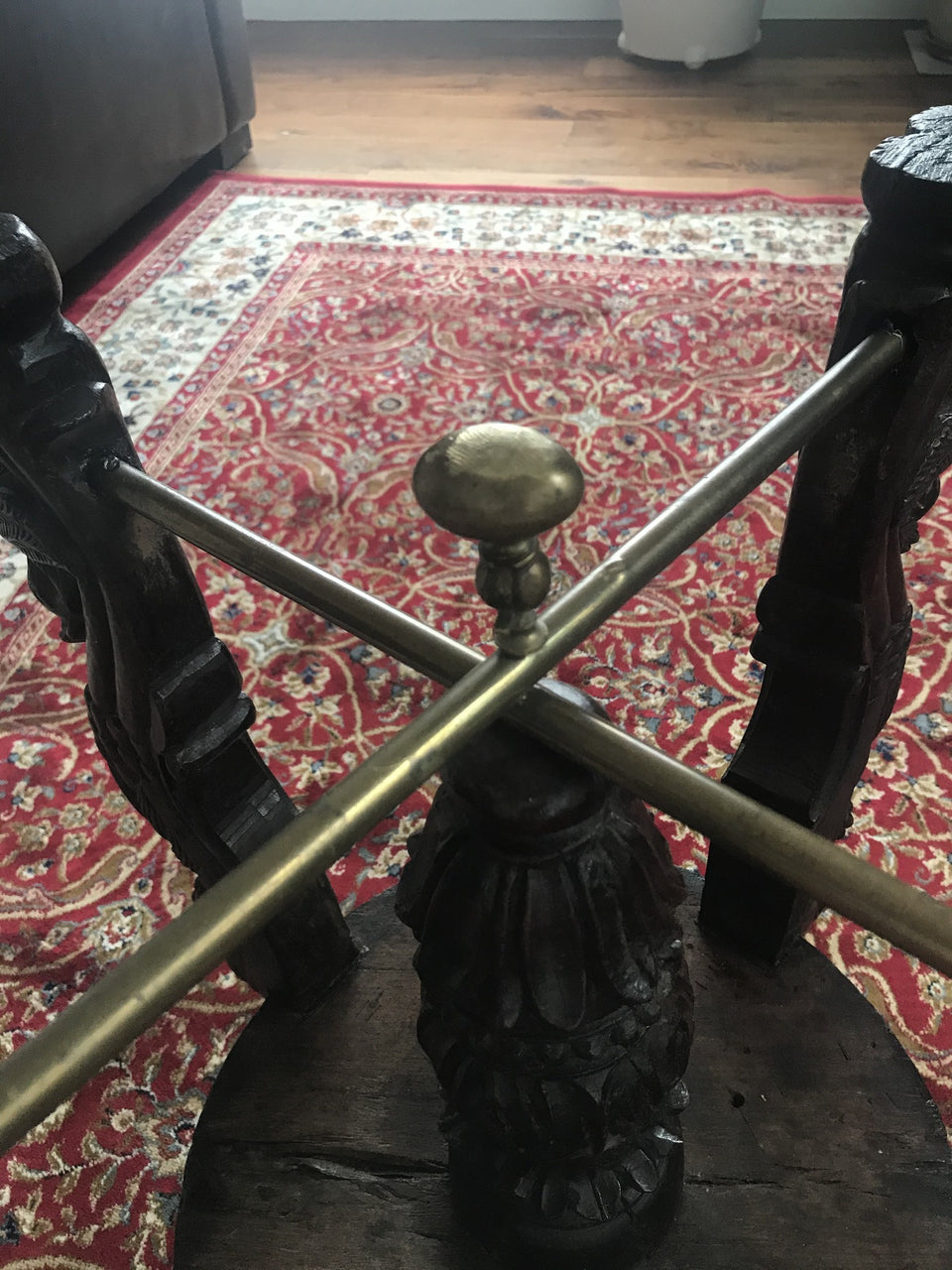carved oriental stool with brass stretcher and adjustable swivel ball