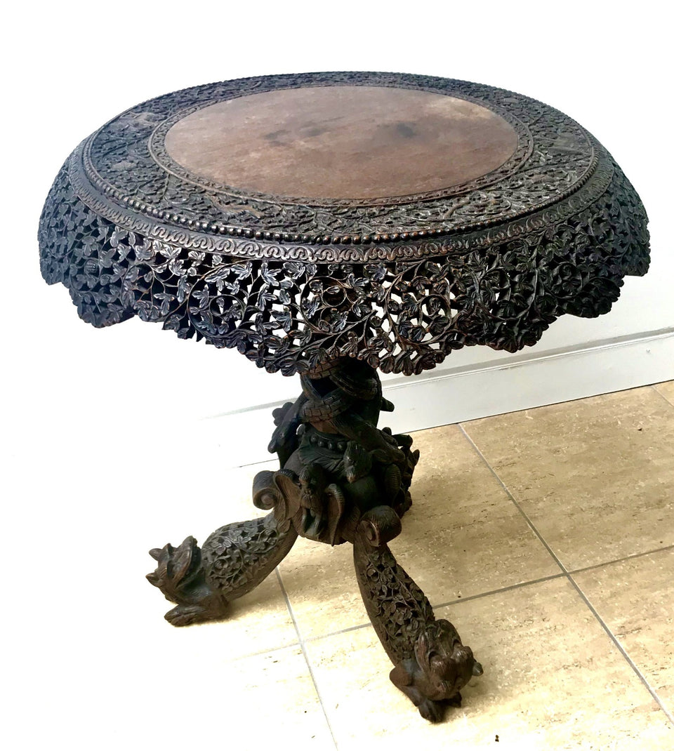 highly carved and pierced anglo-indian hardwood tilt top table with lions and snakes